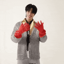 a man wearing a grey sweater and red gloves has the word uppoom on the bottom