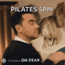 a man is standing next to a woman with his eyes closed and a caption that says pilates 5 pm
