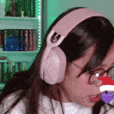 a woman wearing headphones and glasses with a santa hat on her nose