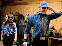 a man wearing a blue hat with a crown on it is standing next to a woman