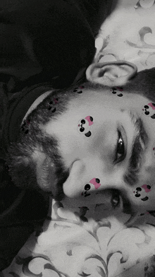 a man with pandas on his face is laying down