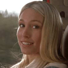 a close up of a blonde woman 's face with a smile on her face