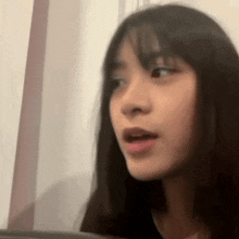 a close up of a woman 's face with her mouth open and looking at the camera .