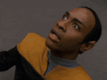 a man in a yellow and black uniform is looking up