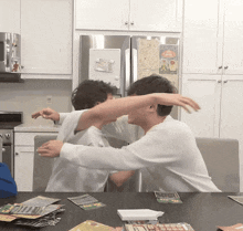 two men are playing a game in front of a refrigerator with a sticker on it that says ' lucky '