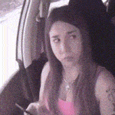 a woman is sitting in the back seat of a car looking out the window