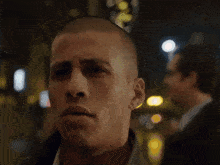 a man in a suit is looking at the camera with a serious look on his face