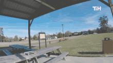 a picnic table in a park with a sign that says tih on it