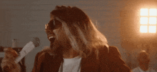 a man singing into a microphone with sunglasses on