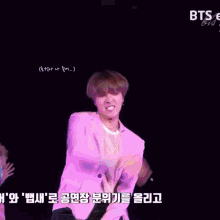 a man in a purple jacket is dancing with another man in a pink shirt and the words bts on the bottom