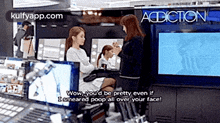 a woman is sitting in front of a mirror getting her makeup done .