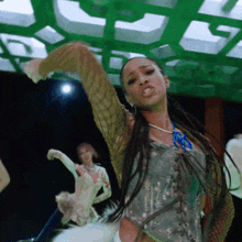 a woman in a corset is dancing in front of a green background