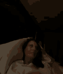 a woman is laying in bed with her head on a pillow .