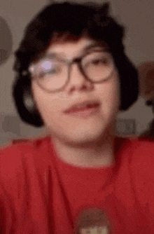 a person wearing glasses and headphones is making a funny face .