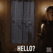 a woman holding a lit candle says hello on a snl ad