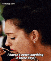 a woman is eating a piece of food and saying `` i haven 't eaten anything in three days . ''