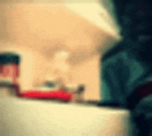 a blurry picture of a person 's face with a red object in the background