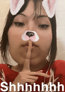 a woman with a cat mask on her face is making a shhh gesture