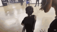a little boy wearing a black shirt with a sticker on it that says ' r113 ' on it