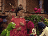 a woman in a red dress is surrounded by sesame street characters