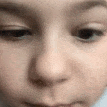 a close up of a child 's face with a slight smile .