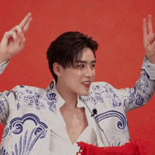 a young man wearing a blue and white jacket is giving the peace sign