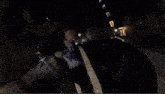 a white car is driving down a street at night
