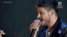 a man singing into a microphone next to a woman with a masterchef logo in the corner