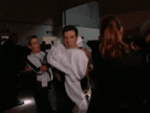 a man with a towel around his neck stands in front of a women 's room