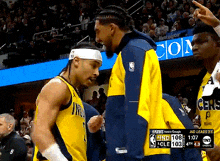 two indiana pacers players are talking to each other during a basketball game