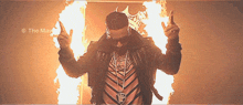 a man with a crown on his head stands in front of flames with the words the mad written above him
