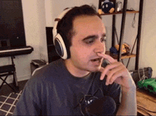 a man wearing headphones is holding his nose while talking into a microphone