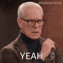 a man wearing glasses and a plaid suit says yeah