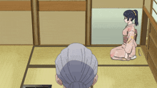 a woman in a pink kimono sits on the floor next to a man