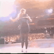 a woman in a black dress is standing on a stage