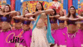 a group of women are dancing in front of a sign that says ' editz ' on it