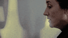 a close up of a woman 's face with a yellow light behind her