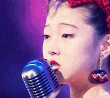 a close up of a woman singing into a microphone with syron written on the bottom right