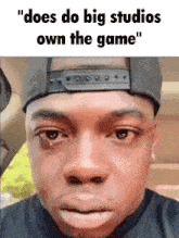a man wearing a hat and a black shirt is crying with the caption " does do big studios own the game "