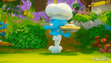 a smurf in a chef 's hat is holding a pie in his hand