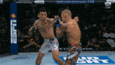 two mma fighters are fighting in front of a espn + banner
