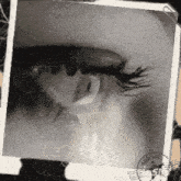 a black and white photo of a woman 's eye with a arrival stamp