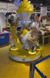 a woman is riding a merry go round with a giant ice cream cone on top