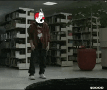 a man with a clown mask on his head is standing in a library