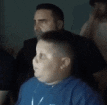 a man is cutting a boy 's hair in a barber shop .