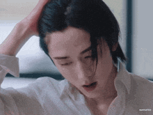 a close up of a person 's face with their hand in their hair .
