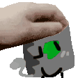 a person 's hand is reaching into a box with a green face .