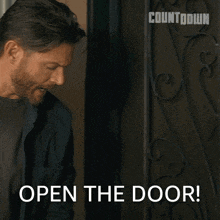 a man is standing in front of a door that says " open the door "