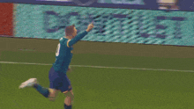 a soccer player wearing a green jersey that says sportpesa