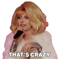 a drag queen singing into a microphone with the words that 's crazy below her